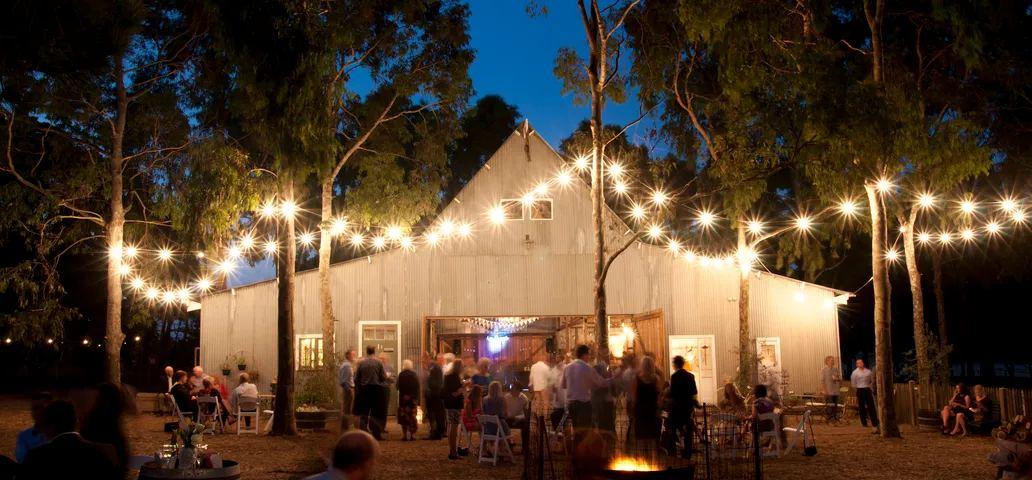 Ivory Barn glowing under festoon lights at night
