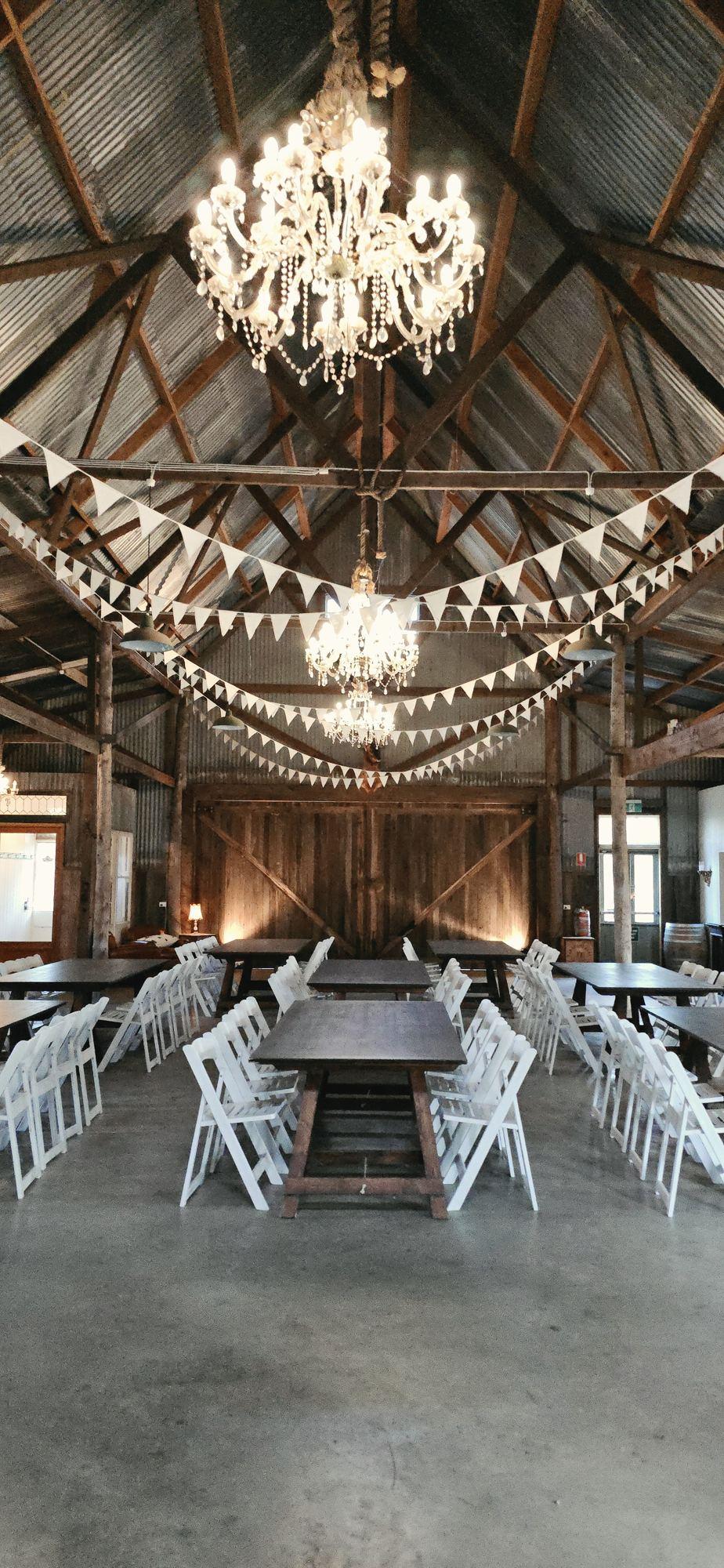 White Americana chairs and trestle tables inside the barn