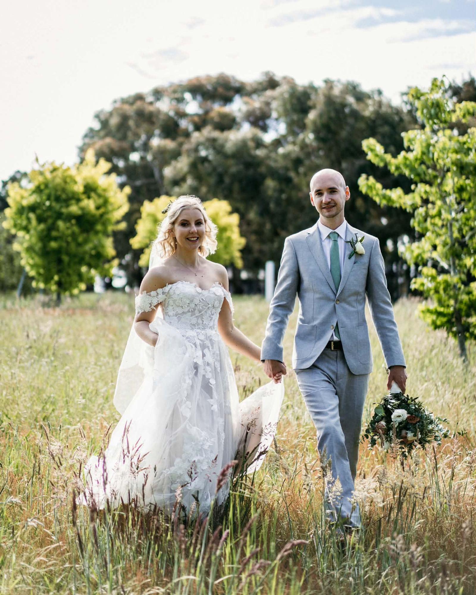 Couple hand in hand amongst the wildflowers